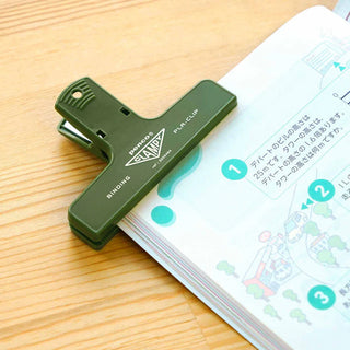 Khaki penco binder clip holding a book open