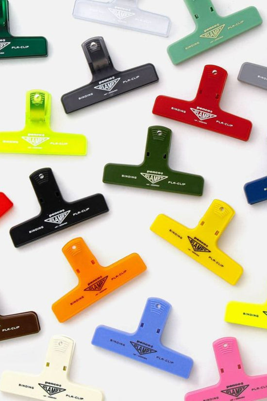 A collection of colorful binder clips in various solid colors displayed on a white background.
