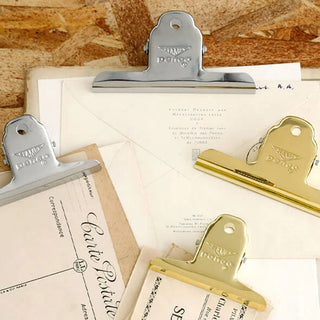 Gold and silver binder clips on papers, assorted finishes for document holding