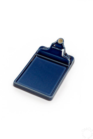 A blue ceramic incense holder tray on a light background
