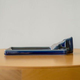 Blue ceramic tray on a wooden surface with a plain background