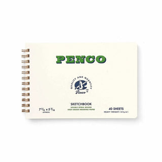 A Penco spiral-bound sketchbook on a clean white background. The sketchbook cover is off-white with green 'PENCO' lettering with the spiral binding visible on the left.