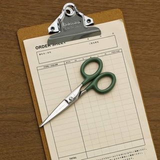 Small stainless steel scissors with green grips and metal loop handles.