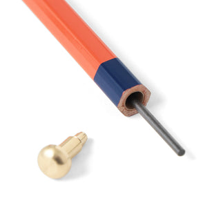 Close-up of a pencil with lead with an orange body and gold metal tip on a white background.