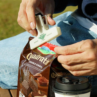 Person using a PENCO Clampy Binding Clip to close a bag of treats.