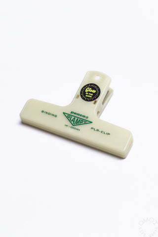 A glow in the dark PENCO Binding Clip laid on a white background.