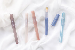 Assorted Kakuno Madoromi fountain pens with translucent barrels and gold nibs