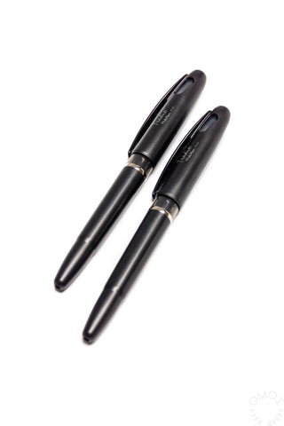 Two black pens on a white background