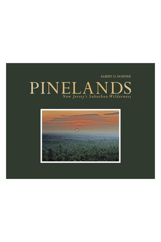 Cover of Pinelands New Jersey's Suburban Wilderness with a photo of the sunset over trees