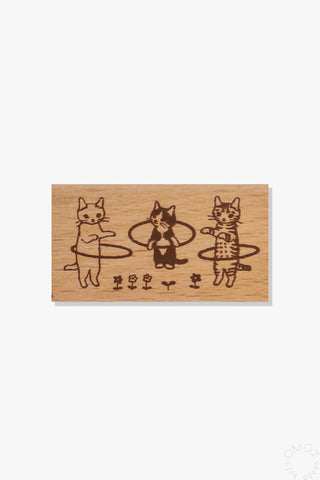 Wooden stamp with illustration of cats hula hooping