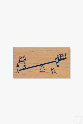 Wooden stamp with illustration of cats on a seesaw