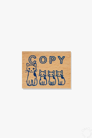Wooden block with cat illustrations and 'COPY' text on a white background