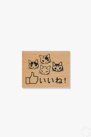 Wooden stamp with cat illustrations and Japanese text on a white background