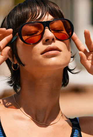 Jenever sunglasses on model, black frames with amber-rose tinted lenses