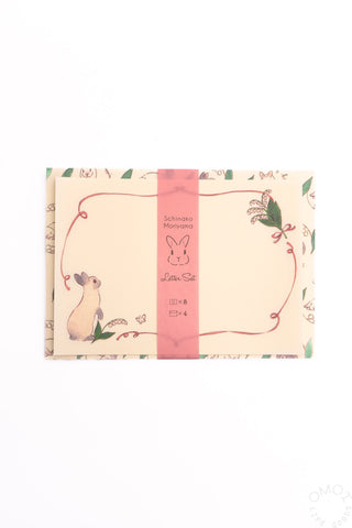 Letter set packaging with rabbit and flower illustrations on a white background