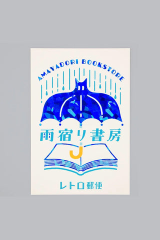 Postcard with design of a bat umbrella over a book on a gray background
