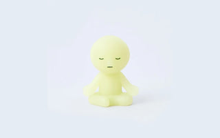 Glow-in-the-dark zipperbite figurine in lotus pose, pale yellow