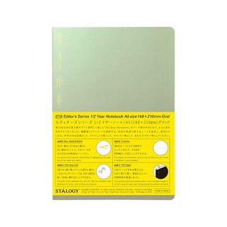 Notebook with green cover and yellow packaging featuring text and branding.