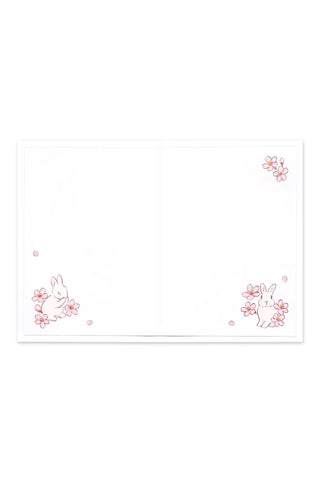 Blank greeting card with pink cherry blossom motif in corners and edges