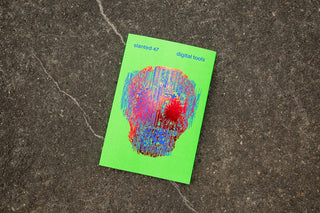 Green magazine with colorful skull design on a textured surface