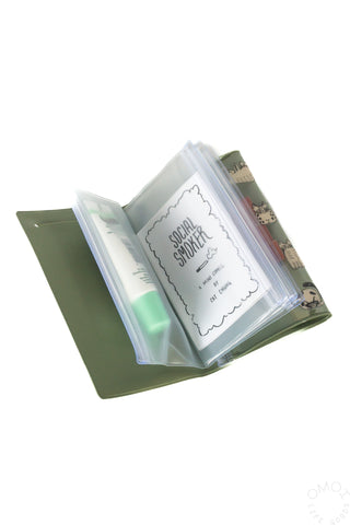 Small green pouch opened, showing interior pockets with cards inside.