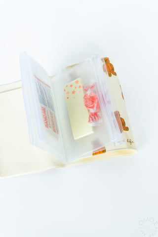 Small 5-pocket pouch with clear pockets holding pink and white packaged items