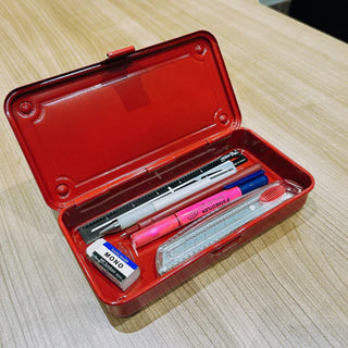 Red trunk toolbox case on wood table, open with stationery tools