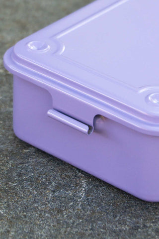 Close-up of a purple storage box with a lid on a textured surface