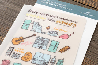 Close-up of travel-themed illustrations on a clear Traveler's notebook folder