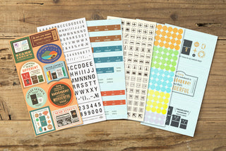 Assorted travel-themed sticker sheets fanned out, including letters and stamps