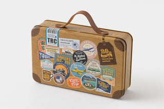 Vintage-style suitcase with travel-themed stickers on a white background