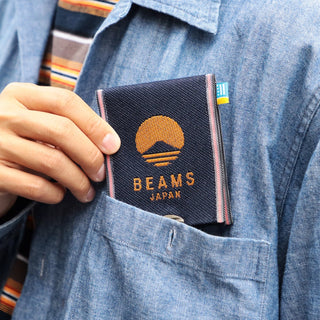 Person wearing a denim shirt with a 'Beams Japan' wallet in the pocket