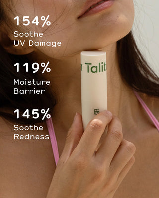 Balm stick held near cheek area for moisturizing application; beige tube visible