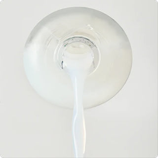 White dandelion essence soo with thick drop dispensing from a bottle cap