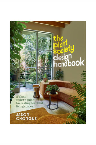 Book cover of 'The Plant Society Design Handbook' with a modern interior design and plants.