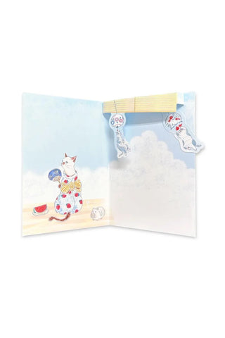 Pop up card  with a cat illustration on a beach, featuring wind chimes