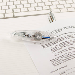 Clear correction tape on a piece of paper with a keyboard in the background