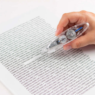 Hand using a correction tape on a printed document
