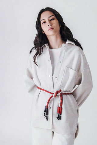 Person in jacket wearing ropes as belt