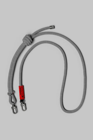 A gray and black checkered rope with a knot, metal swivel clips, and a small red brand tag on a solid gray background.