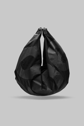 A black slouchy shoulder bag with a glossy finish and large letters, centered against a solid gray background.