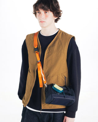 Orange crossbody utility sling strap worn on black bag