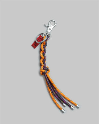 Keychain with braided orange and colorful cord on a gray background