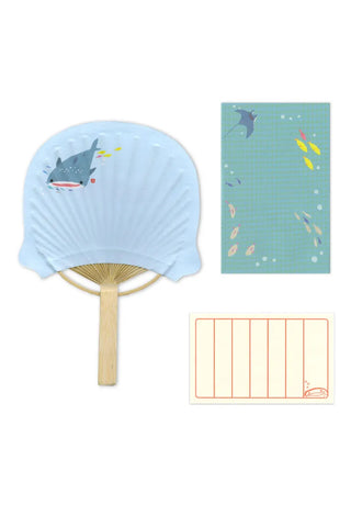 Light blue fan with shark design on a white background with stationery
