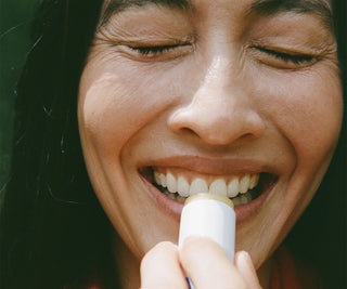 Person applying lip balm with a blurred background