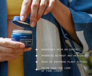 Person opening a jar of Ursa Major Golden Hour Recovery Cream with product details listed.