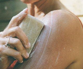 Person applying soap to their shoulder with a blurred background