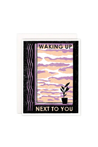 Letterpress greeting card with purple sunset stripes and text 'WAKING UP NEXT TO YOU'.