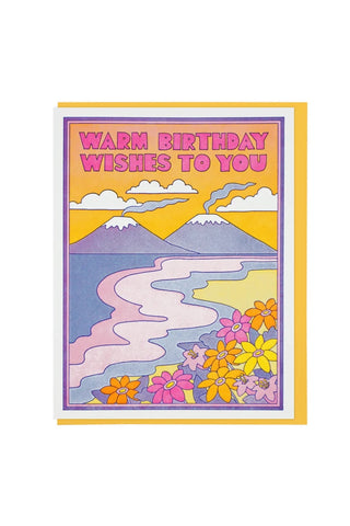 Birthday greeting card with colorful mountain landscape and floral border, warm wishes text