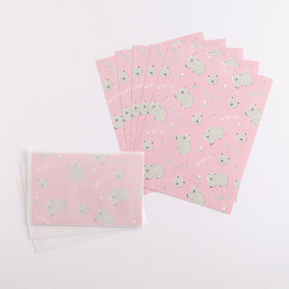 Letter set with wombat design on pink paper next to envelopes